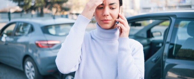 Woman calling insurance assistance after car crash