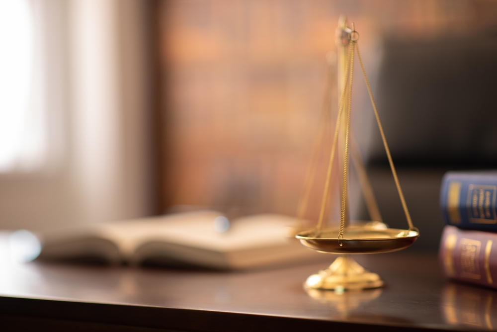 Golden scales of justice and open law book symbolizing a client’s right to change their lawyer.