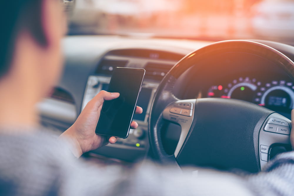 Driver holding a cellphone while operating a vehicle in Los Angeles.
