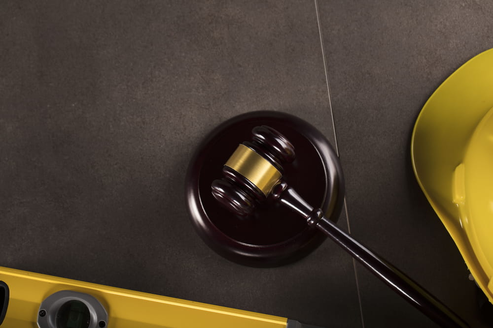 Judge's gavel and safety equipment representing legal claims after a distracted driving accident.