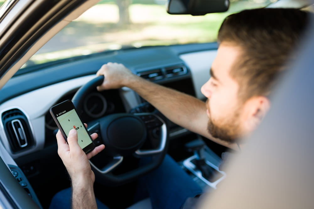 Rideshare driver viewing a navigation app while operating a vehicle in Los Angeles.